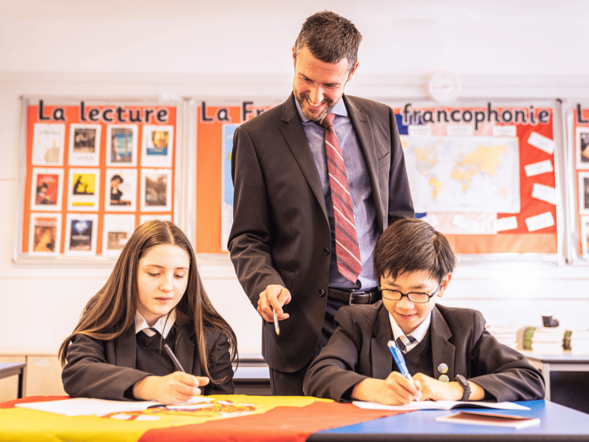 A Languages teacher helps two students with their work at Cheadle Hulme High School, the founding school of the Laurus Trust that has been selected as a lead Language Hub school in England.