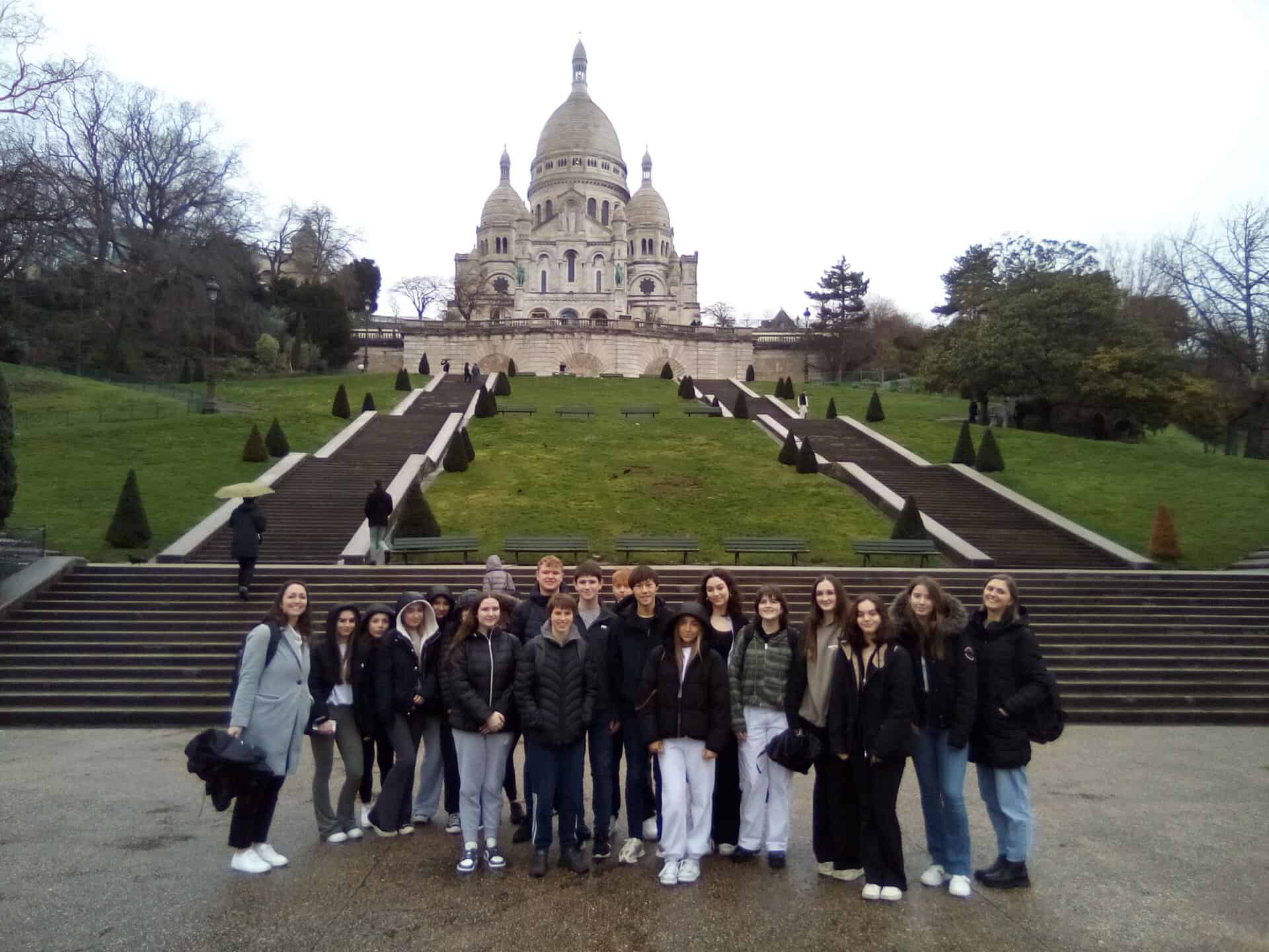 Students from Laurus Trust secondary schools stand at the bottom of the steps leading up to Sacre-Coeur.
