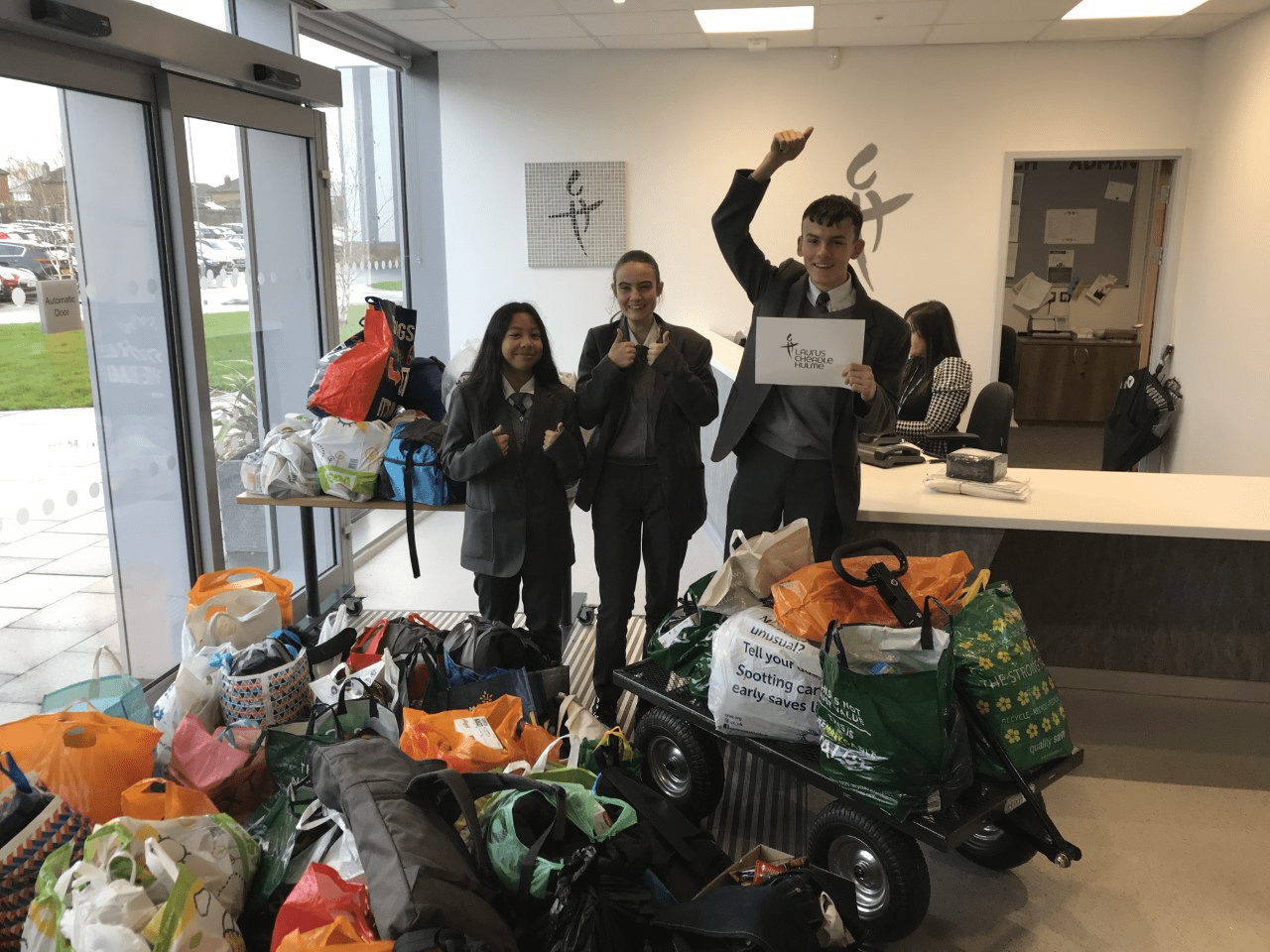 student representatives stand next to all the donations